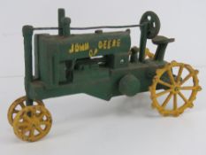 A reproduction vintage style cast metal John Deere tractor measuring 30cm in length.