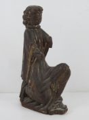 An ecclesiastical wooden carving of a robed man kneeling, a/f, 35cm high.