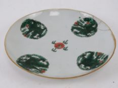 A late 19th/early 20thC Chinese dish having four green Imperial dragon and pearl roundles upon and
