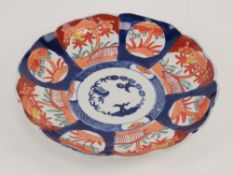 An Oriental dish decorated in blues and reds having fluted border, 21cm dia,