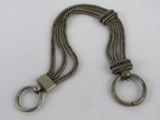 A white metal Albertina watch chain having three substantial curb link chains with floral patterned