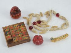 An Oriental wooden fifteen piece captive puzzle, two carved Oriental gourds, a shell 'caterpillar',