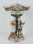A large Capodimonte style centrepiece pedestal fruit bowl having two figures upon,