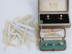 A matched pair of shirt studs, one marked 9ct, in fitted box,