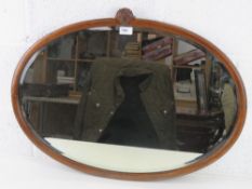 A good mahogany framed bevelled edge oval wall mirror with shell crest over, 77 x 55cm.