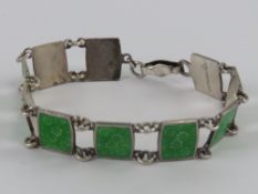 A sterling silver bracelet having floral design green enamelled panels, enamel slightly a/f, 18.