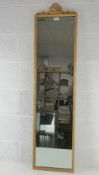 A c1960s gilded full length wall mirror with pierced ribbon crest over, 135 x 34cm.