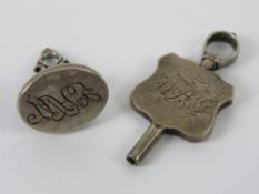 A white metal seal having indistinct hallmarks upon together with a white metal watch key,