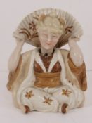 An early 20thC nid-nod figurine of a woman in Oriental dress. Approx 9cm high.