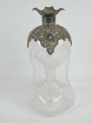 A late Victorian 'Glug glug' waisted decanter having overlaid silver decoration and spout,