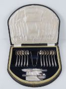 A cased set of silver plated teaspoons with cake knife and dessert spoon by Dickson,