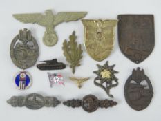A quantity of assorted reproduction WWII German badges. Thirteen items.