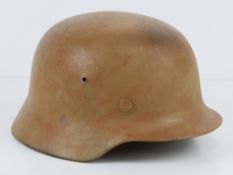 A WWII German M40 helmet having partial detail upon with liner and chin strap.