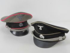 Two reproduction WWII German peaked caps being SS Officer's cap and Allgemeine Officer's cap.