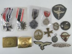 A quantity of reproduction WWII German militaria including badges, buckles, medals, etc.