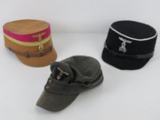 Three reproduction WWII German caps inc SS Kepi, SA Kepi (size 59), and an M43 cap.