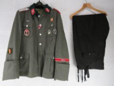 A WWII Italian SS Tunic with insignia size XXXL, together with a pair of blue trousers size XXXL.