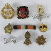A quantity of British military cap badges together with a medal bar and a commemorative Waterloo