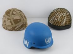 Two British Mk 6 helmets, one with helmet net size L. Together with a UN Blue Ballistic helmet.