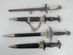 Four reproduction WWII German dress daggers in sheaths.