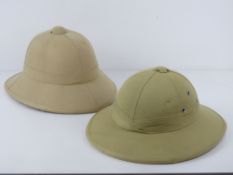 Two contemporary Pith helmets, one bearing German label within, one made in Vietnam.