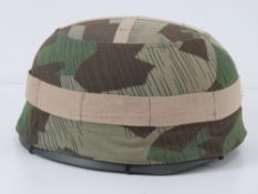 A reproduction WWII German Fallshirmjager (paratrooper) helmet with helmet cover and liner.