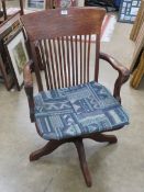 A good 1930s oak swivel office chair raised over quatroform base and having sprung back.