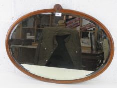 A good mahogany framed bevelled edge oval wall mirror with shell crest over, 77 x 55cm.