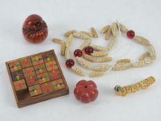 An Oriental wooden fifteen piece captive puzzle, two carved Oriental gourds, a shell 'caterpillar',