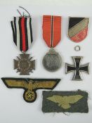 A German WWII Russian Winter Campaign medal, a German Afrika Korp helmet badge,