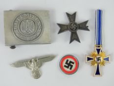 A quantity of reproduction German badges and belt buckle.