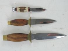 Two fighting knives, together with a miniature knife.