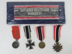 A quantity of assorted reproduction militaria; 1x German Armbands. 4x German WWII German Medals.