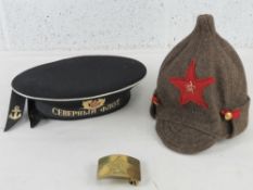 A Russian Navy cap with ribbon, a Russian Budenovka hat and a Russian Army brass belt buckle.