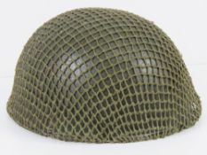 A British Paratrooper's helmet with liner and helmet net, dated 1983.