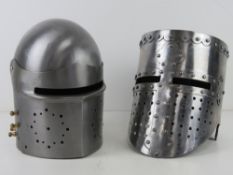 Two reenactors medieval style knights helmets.