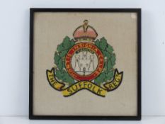 A framed WWII sweetheart embroidery of The Suffolk Regiment.
