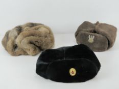 Three Russian winter hats, one bearing Soviet Military label upon,