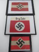Three WWII German arm bands in frames.
