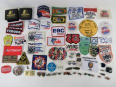 A quantity of assorted motor racing themed cloth patches and enamel badges,