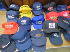 A large quantity of motor racing themed base ball caps.