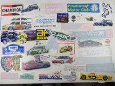 A large quantity of assorted motor racing themed bumper stickers, window stickers etc.