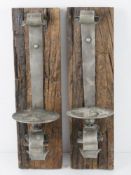 A pair of heavy blacksmith made oak and metal candle sconces, each 46cm in length.