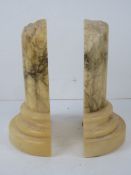 A pair of carved alabaster book ends in the form of Roman column bases, approx 20cm high.