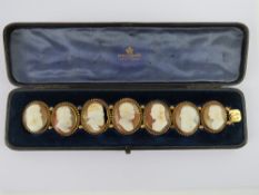 A seven panel carved shell cameo bracelet having seven male portraits set in yellow metal,