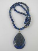 A teardrop shaped lapis lazuli pendant on beaded chain having 925 silver clasp,