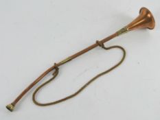 A copper and brass hunting horn measuring approx 42cm in length.