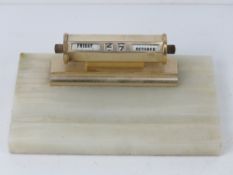 An alabaster desk tidy having calendar over, 21cm wide.
