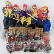 A quantity of marionette puppets, wooden and cloth construction, within wicker hamper.