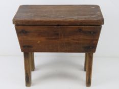 An oak footstool, lid lifting to reveal compartment within. 38cm wide.